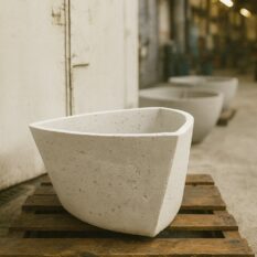 Jasna betonowa donica w kształcie trójkątnym w przekroju